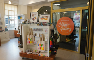 Several items on display in the Experience Barnsley Gift Shop, including a bag and some books.